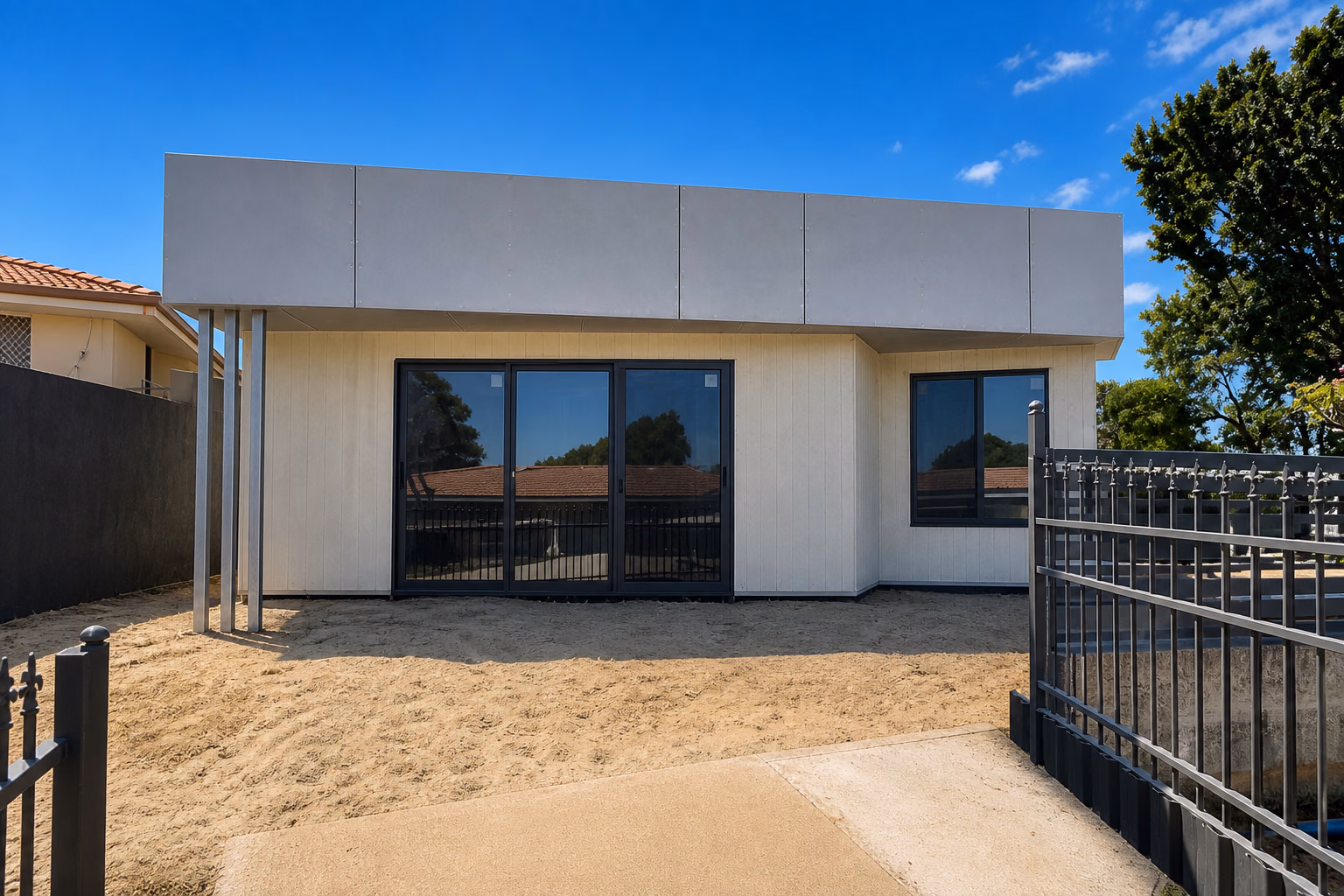 A cream granny flat with dark-framed sliding doors