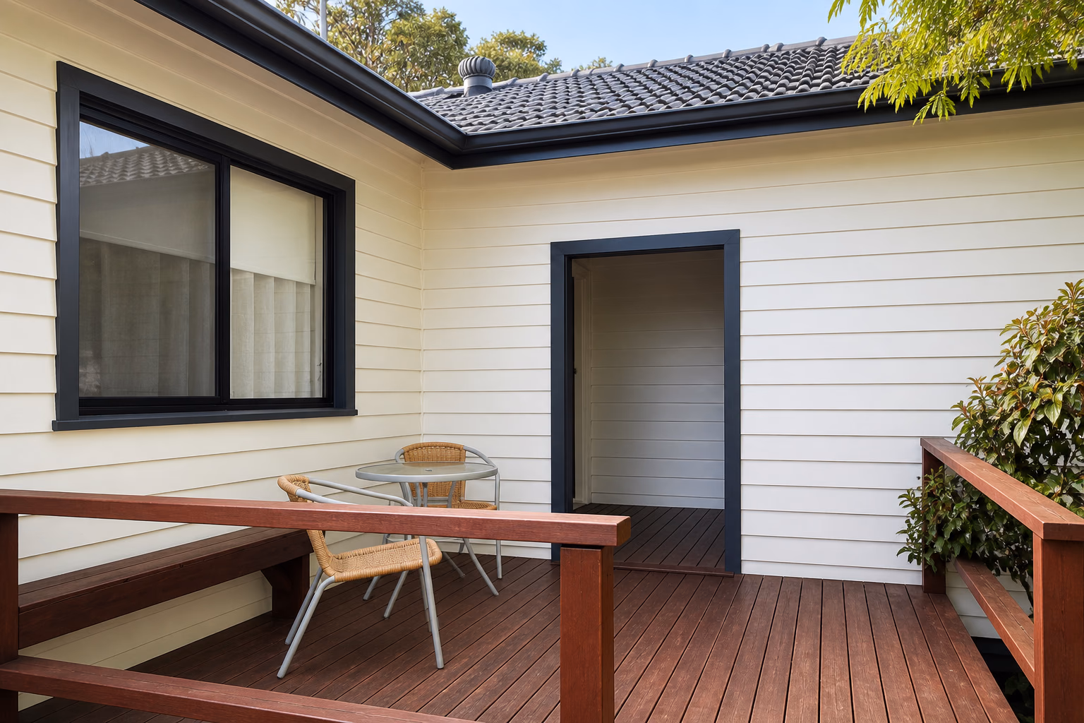 A finished home with cream weatherboard cladding and a timber deck