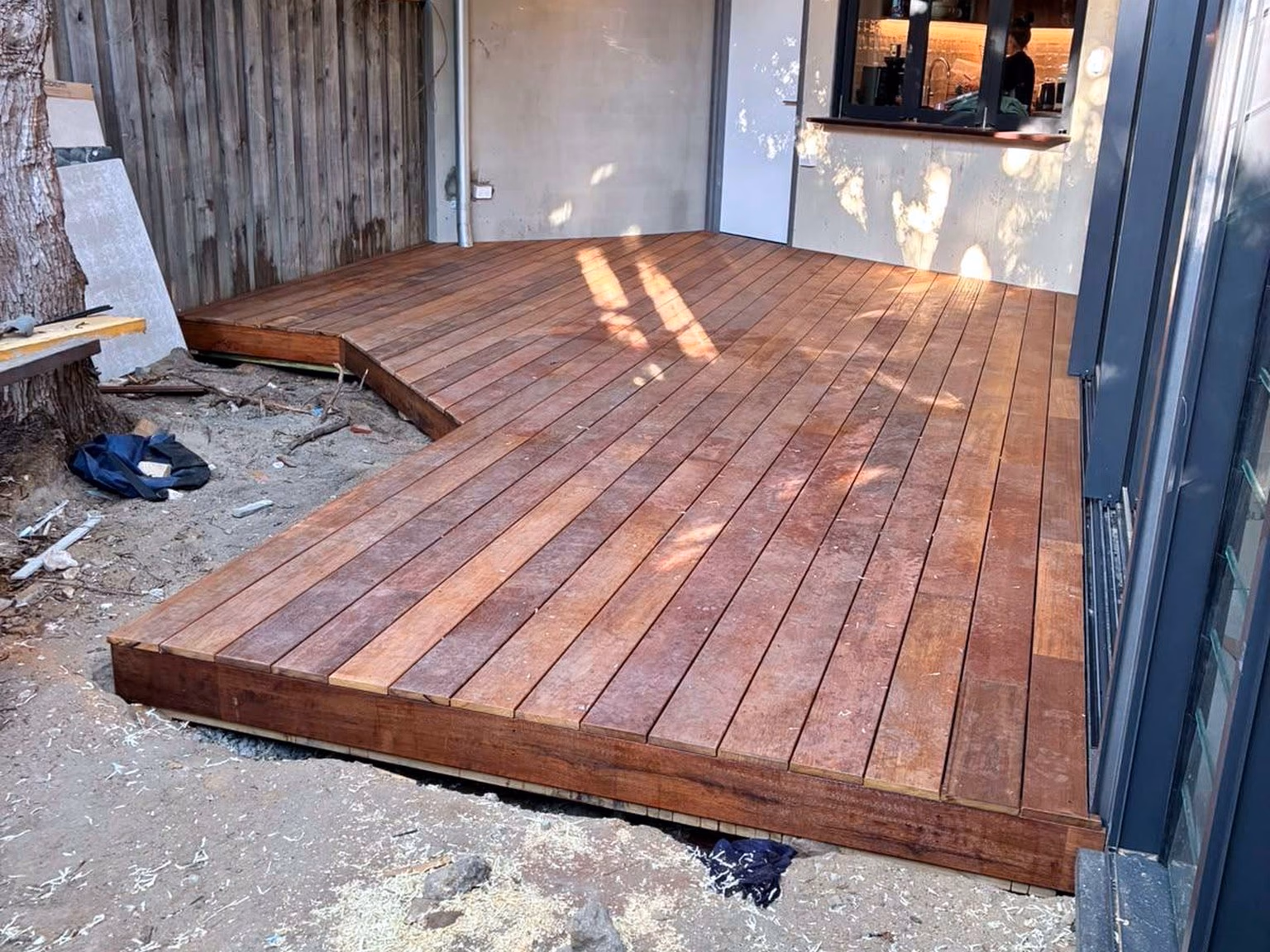 An L-shaped finished hardwood deck beside a home