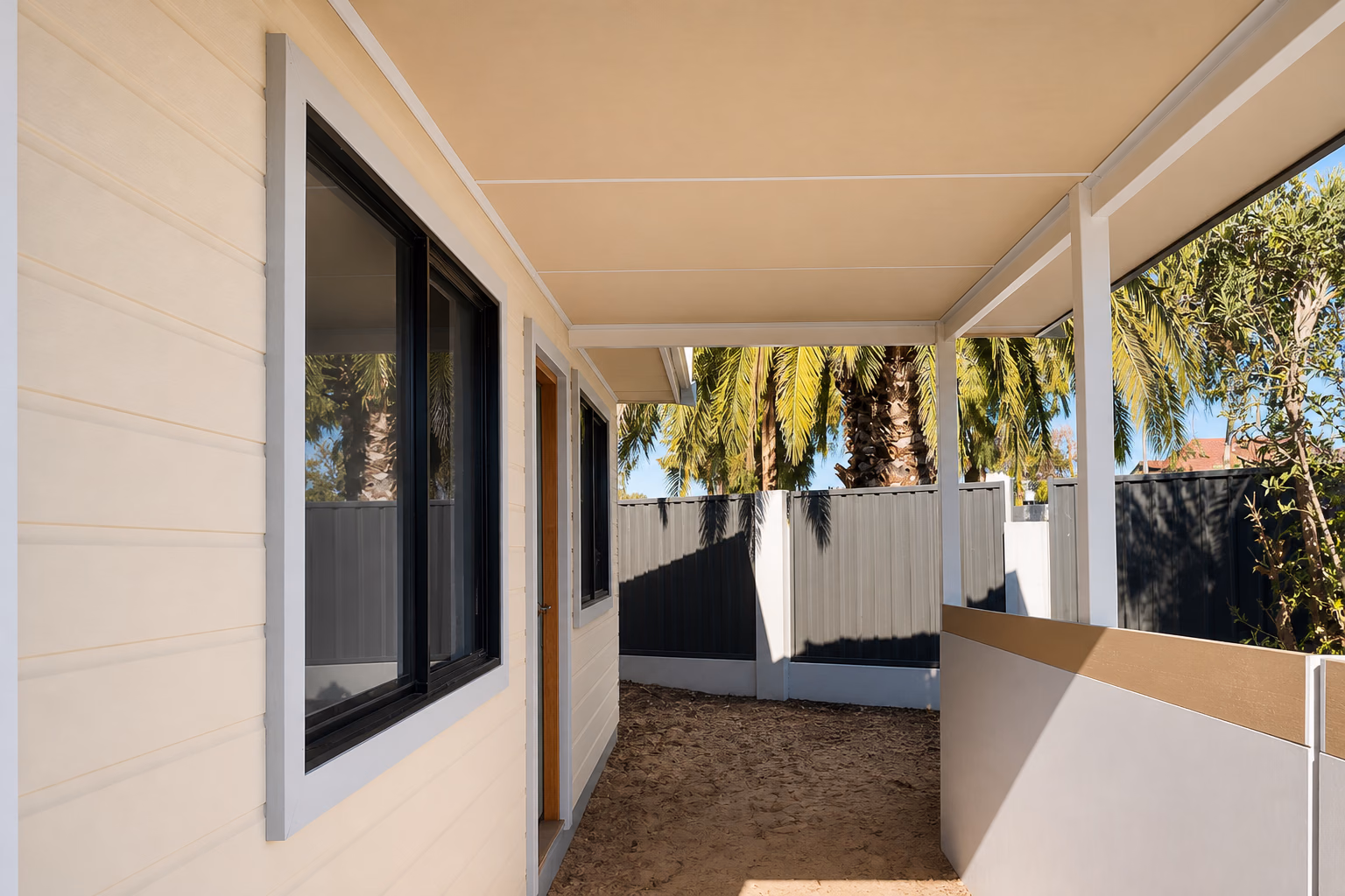 A covered granny-flat walkway with weatherboard cladding and timber posts