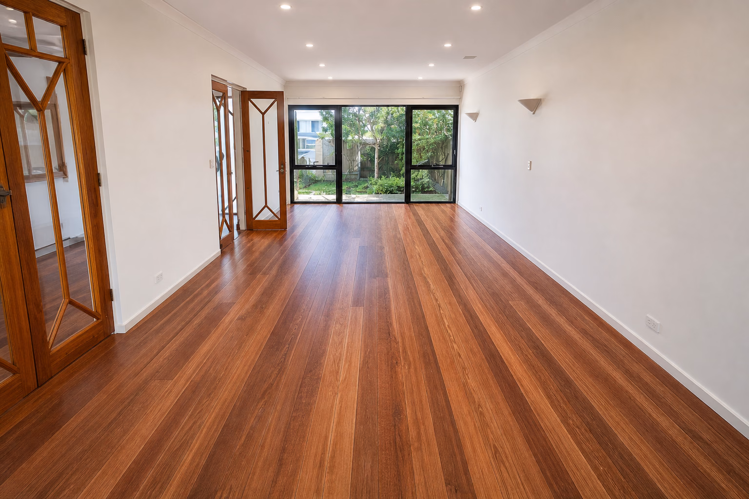 A long run of finished hardwood flooring toward garden doors